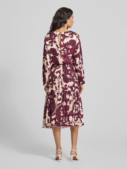 Frauenmodel trägt Cocktailkleid mit Rundhalsausschnitt von Rinascimento aus Material-Mix mit Stretch-Anteil, Plisseefalten, körpernahe Passform, gemusterte Optik in Creme und Bordeaux, Rückenlänge 113 cm, Brustweite 44 cm, Ärmellänge 59 cm, Ganzkörperansicht Rückansicht.