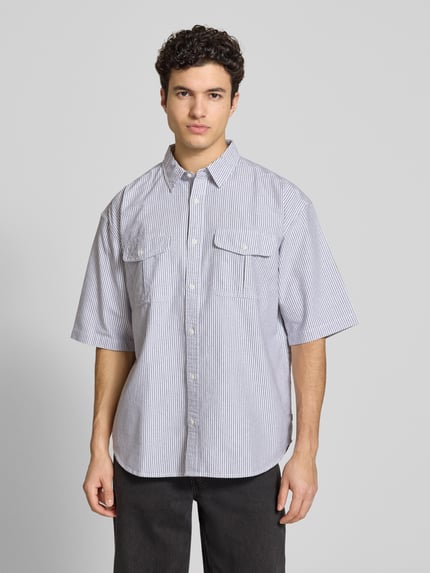 Männermodel trägt Loose Fit Freizeithemd aus reiner Baumwolle Modell 'PACIFICA' von Levi's® mit Optik:Allover-Muster, gestreift, Hemdkragen, einreihiger Knopfleiste, Kurzarm, abgerundetem Rumpfabschluss und Brusttaschen, Ganzkörperansicht von vorne.