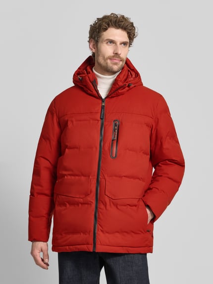Männermodel trägt Steppjacke mit Pattentaschen von camel active in kräftigem Rot, sichtbarer Reißverschluss, Ganzkörperansicht von vorne. Gerade Passform, Kapuze mit Tunnelzug, Brusttasche mit Reißverschluss, dicke wattierte Textur. Rückenlänge, Schulterbreite, Brustweite und Ärmellänge bei Größe M: 80/51/64/67 cm.