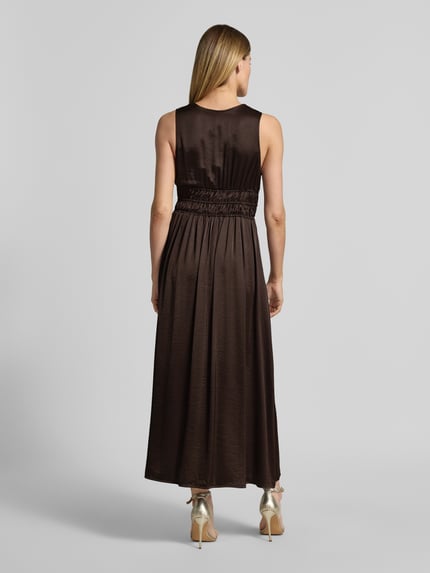 Vrouwenmodel draagt maxi-jurk met diepe V-hals model 'Marja' van mbyM, materiaalmix met viscose, getailleerd model, ruglengte maat S 130 cm, borstwijdte maat S 36 cm, rugaanzicht volledige lichaamsopname