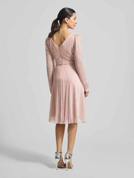 Vrouwenmodel draagt Regular Fit Jurk in wikkellook van TROYDEN COLLECTION, glitter mesh, V-hals, getailleerd, ruglengte 90 cm, geheellichaamsaanzicht achterkant.