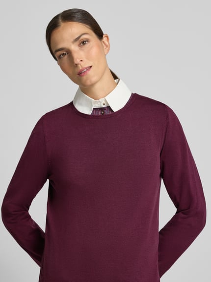 Kobiecy model nosi Regular Fit Pullover aus Baumwoll-Viskose-Mix od s.Oliver RED LABEL, kolor ciemnofioletowy, gładka tekstura, zbliżenie na górną część ciała.