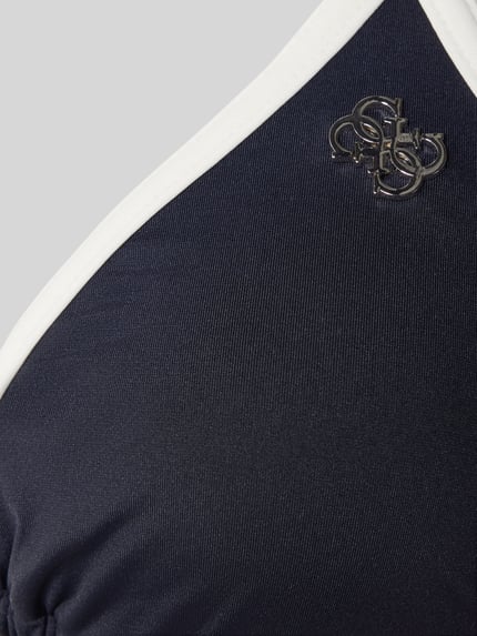 Frauenmodel trägt Bikini-Oberteil mit Logo-Applikation Modell 'Niki' von Guess, Elastischer-Material-Mix, Nahaufnahme Oberkörper.