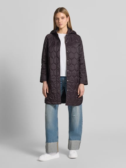 Vrouwenmodel draagt Regular Fit lange jas in stiksels model 'Solene' van CARS JEANS, zwart, met opstaande kraag, capuchon, steekzak, volledige knoopsluiting, ruglengte maat S 95 cm, schouderbreedte 42 cm, borstwijdte 53 cm, mouwlengte 47 cm, voorkant volledig zichtbaar, geheel beeld.
