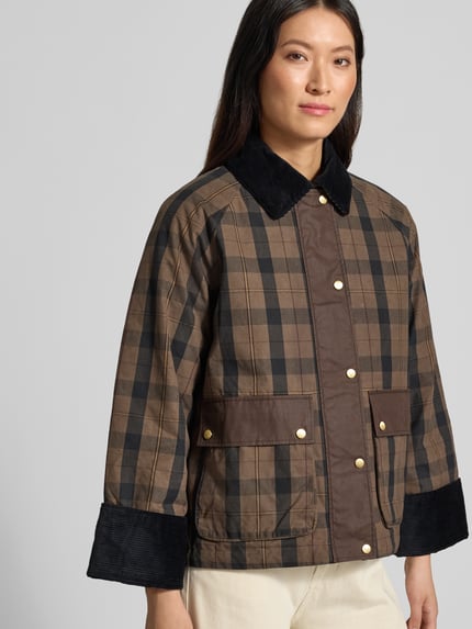 Vrouwenmodel draagt Regular Fit Hemdjacke met all-over motief van GANT in bruin en zwart met gouden knopen, Dames parka, halfclose-up van voren.