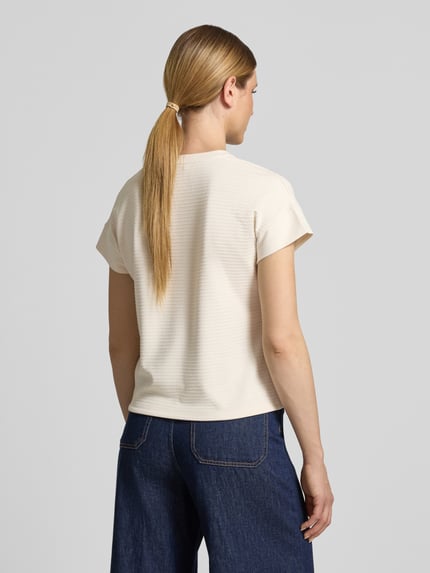 Vrouwenmodel draagt Regular fit T-shirt uit viscosemix model 'Solke' van OPUS, structuurpatroon, crèmekleurig, detail van tunnelkoordzoom, rugaanzicht, context: dames T-shirt, elastische viscosemix, ruglengte maat 36: 55 cm.