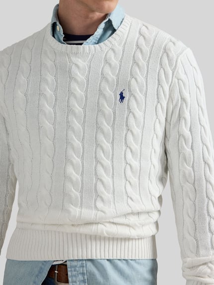 Mannelijk model draagt Regular Fit Strickpullover aus reiner Baumwolle van Polo Ralph Lauren, wit, kabelpatroon, crew neck, gebreid katoen, logo-detail links op de borst, close-up bovenlichaam.