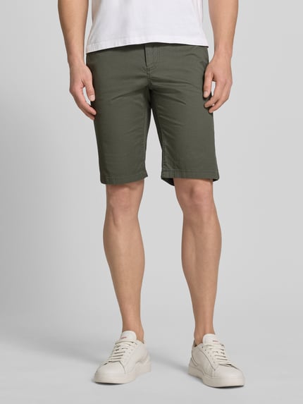 Männermodel trägt Slim Fit Chinoshorts aus Baumwoll-Mix von Tom Tailor in grün mit Optik:Allover-Muster, Twill, Ganzkörperansicht von vorne.