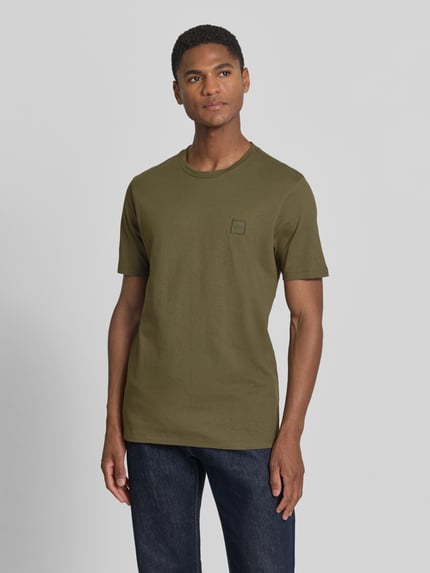 Mannenmodel draagt Regular Fit T-Shirt uit puur katoen model 'TALES' van BOSS Orange in effen olijfgroen met label patch, ronde hals, korte mouw, vooraanzicht bovenlichaam.