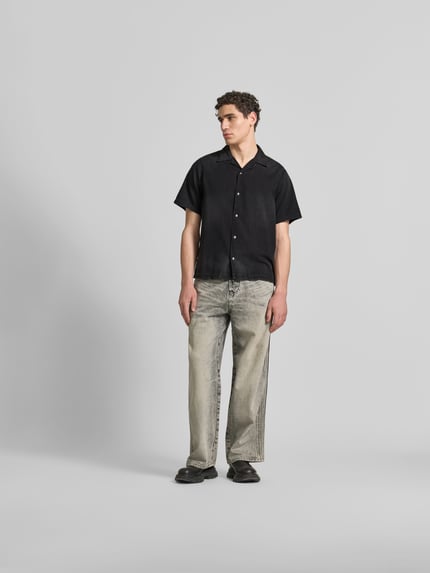Männermodel trägt Regular Fit Jeanshemd aus Baumwolle von Diesel in Schwarz mit Druckknopfleiste und Reverskragen, Ganzkörperansicht von vorne. Reine Baumwolle, Kurzärmelig, Rückenlänge 72 cm, Schulterbreite 44 cm, Ärmellänge 31 cm.