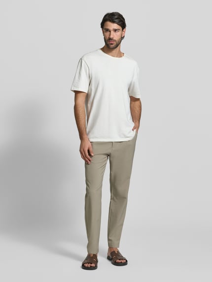 Männermodel trägt Slim Fit Stoffhose mit Strukturmuster von CRUNA in Beige, Elastischer-Material-Mix, Ganzkörperansicht von vorne.