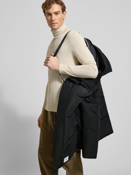 Männermodel trägt Regular Fit Steppmantel mit Logo-Patch Modell 'Zeno' von khujo in Schwarz, Stepp-Optik, Ganzkörperansicht von vorne.