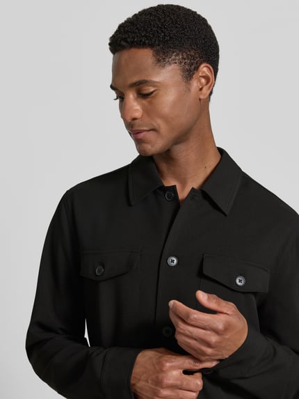 Männermodel trägt Relaxed Fit Hemdjacke mit Brusttaschen von Lindbergh aus Material-Mix mit Viskose-Anteil, Knopfleiste, Kentkragen, Nahaufnahme Oberkörper.