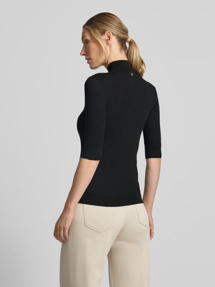 Vrouwenmodel draagt Slim Fit Longsleeve uit pure lanawol Maglia Costine van Liu Jo White, halftransparant, zwarte stof, rugaanzicht.