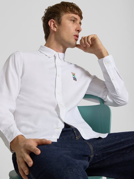 Männermodel trägt weißes Slim Fit Freizeithemd mit Button-Down-Kragen von CHILL PILL, reine Baumwolle, Motiv-Stitching, Nahaufnahme Oberkörper.