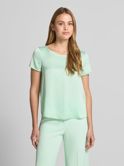 Vrouwenmodel draagt Blusenshirt mit Rundhalsausschnitt und abgerundetem Saum van Rinascimento in mintgroen, loose fit, materiaal-mix met stretch, afgeronde zoom, ruglengte maat S 52 cm, volledige lichaamsaanzicht van voren.