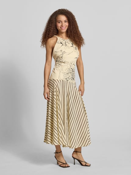 Frauenmodel trägt Maxikleid im Allover-Look Modell 'MILLE' von Topshop in Beige mit schwarzen Streifen und Blumen, taillierter Schnitt, feine Struktur, Träger im Perlen-Look, Rückenlänge bei Größe 36: 134 cm, Brustweite 38 cm, Ganzkörperansicht von vorne.