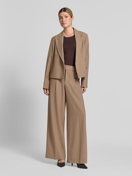 Frauenmodel trägt Slim Fit T-Shirt aus Viskose-Mix von Rich & Royal, braun, elastisch, Kräuselsäume, Rundhalsausschnitt, Nahaufnahme Oberkörper.