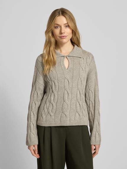 Vrouwenmodel draagt gebreide pullover met kabelpatroon, materiaalmix met katoen, relaxed fit, platte kraag, druppelvormige hals, model 'Pavana Peony' van MSCH Copenhagen, dames, kleur taupe, ruglengte en mouwlengte 52 cm, voorkant, bovenlichaam close-up.