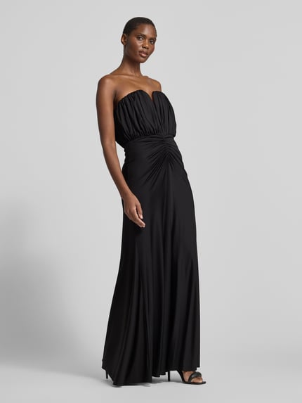 Frauenmodel trägt Abendkleid mit geraffter Frontpartie von Self-Portrait in Schwarz, Maxi-Länge, schulterfrei, aus Jersey, Ganzkörperansicht von vorne