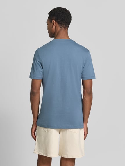 Męski model nosi Regular Fit T-Shirt aus reiner Baumwolle von s.Oliver RED LABEL, efekt: jednolity kolor, krój regular fit, nadruk z logo, okrągły dekolt, krótki rękaw, wykończenie materiału: dżersej, materiał: czysta bawełna, całkowity widok z tyłu.
