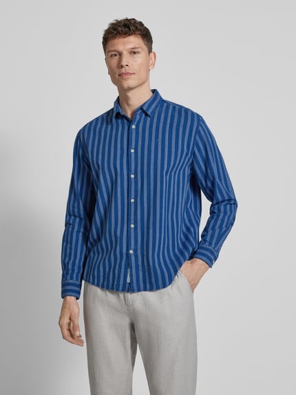 Männermodel trägt Regular Fit Jeanshemd aus reiner Baumwolle Modell 'PAXTON' von Pepe Jeans, blau gestreift, Denim, Ganzkörperansicht von vorne.
