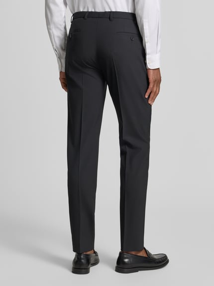 Männermodel trägt Anzughose mit Bügelfalten Modell 'Apollo' von DIGEL, Slim-Fit, Material-Mix mit Schurwoll-Anteil, Ganzkörperansicht Rückansicht.