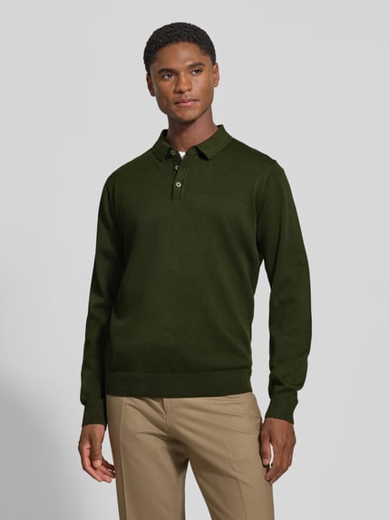 Männermodel trägt Strickpullover mit Polokragen und Knopfleiste von Fynch-Hatton in Dunkelgrün, Baumwolle, Regular Fit, Ganzkörperansicht von vorne.