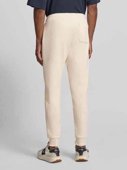 Männermodel trägt Regular Fit Sweathose aus Baumwoll-Mix von Polo Ralph Lauren in Creme, glatte Struktur, Ganzkörperansicht Rückansicht, Herren