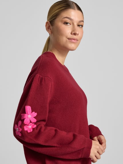 Frauenmodel trägt Strickpullover aus Wolle mit Stitchings und Perlen von Christian Berg Woman, bordeauxrot, Relaxed Fit, Detailaufnahme Oberkörper.