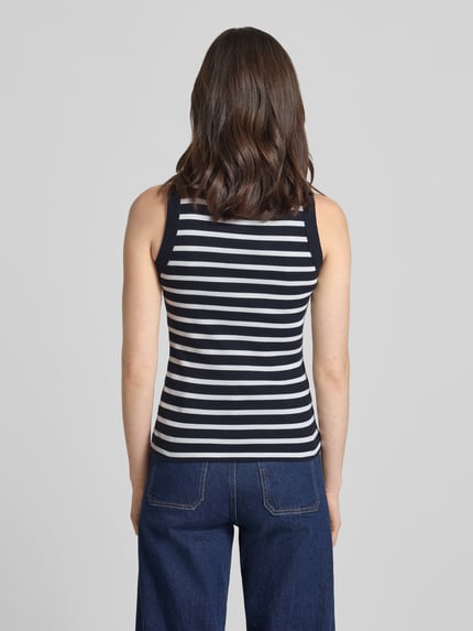 Frauenmodel trägt Tanktop mit Rippenstruktur Modell 'OLINA' von Drykorn in marineblau-weißen Streifen, Reine Baumwolle, eng anliegender Schnitt, Rückenlänge bei Größe S: 55 cm, Ganzkörperansicht Rückansicht.