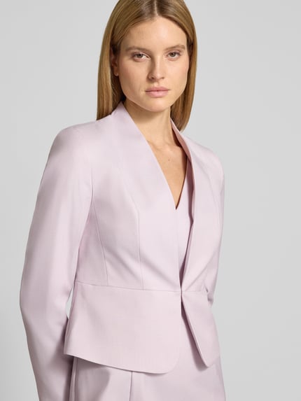 Vrouwenmodel draagt Fein strukturierter Blazer mit V-hals van Christian Berg Woman Selection, materiaalmix met viscose, slim fit, lichtroze, fijn gestructureerd. Nahaufnahme bovenlichaam.