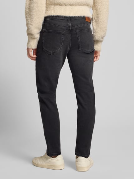 Männermodel trägt dunkle Slim Fit Jeans mit 5-Pocket-Design von Calvin Klein Jeans, Baumwoll-Elasthan-Mix, Ganzkörperansicht Rückansicht.