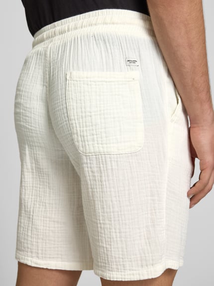 Männermodel trägt Shorts mit Strukturmuster Modell 'AIDEN' van Jack & Jones, katoenmix, straight fit, elastische taille, achteraanzicht detailopname.