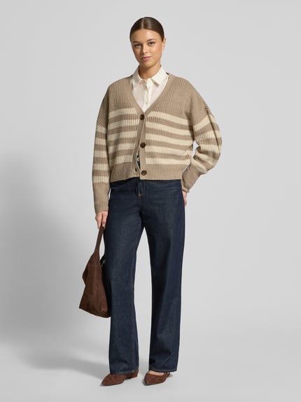 Frauenmodel trägt Relaxed Fit Strickjacke mit V-Ausschnitt Modell 'LEA' von Vero Moda in Melange-Optik, Strick, Knopfleiste, Ganzkörperansicht von vorne.