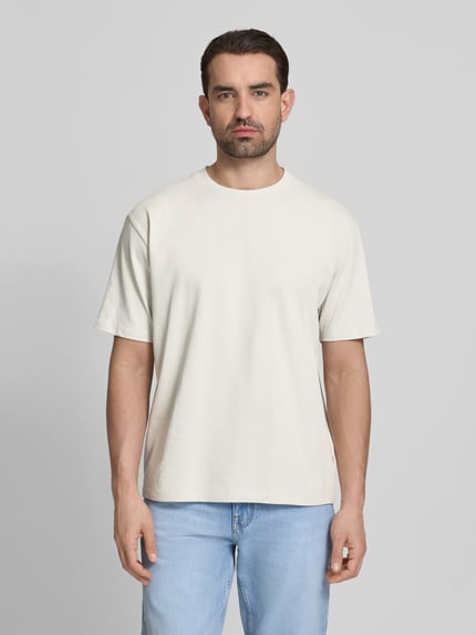 Männermodel trägt Oversized T-Shirt mit Rundhalsausschnitt von Lindbergh in offwhite aus puur katoen mit labeldetail, oversized fit, ruglengte maat M 70 cm, Ganzkörperansicht von vorne