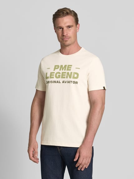 Mannenmodel draagt T-shirt met ronde hals en labelprint van PME Legend in offwhite, puur katoen, regular fit, ruglengte maat M 64 cm. Ganzlichaansicht van voren.