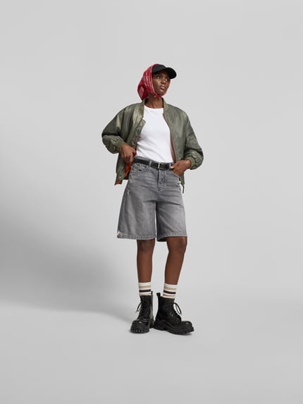 Vrouwenmodel draagt Relaxed Fit Jeansshorts uit katoen van Diesel, grijs met destroyed-look, 5-pocket, knoop- en ritssluiting, Ganzkörperaanzicht van voren.