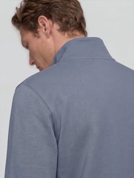 Männermodel trägt Troyer mit Logo-Patch Zetrust von BOSS Orange in Graublau, strukturierter Jersey, gerippter Abschluss, Nahaufnahme Rückansicht.