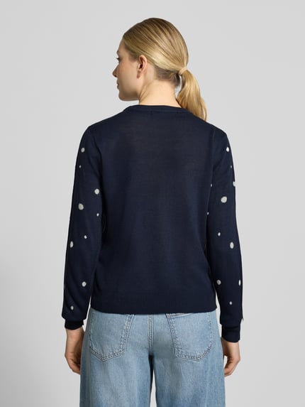 Frauenmodel trägt Pullover mit Rentier-Motiv von VERO MODA in mehrfarbiger Strickoptik, Rundhals, lange Ärmel, Ganzkörperansicht Rückansicht
