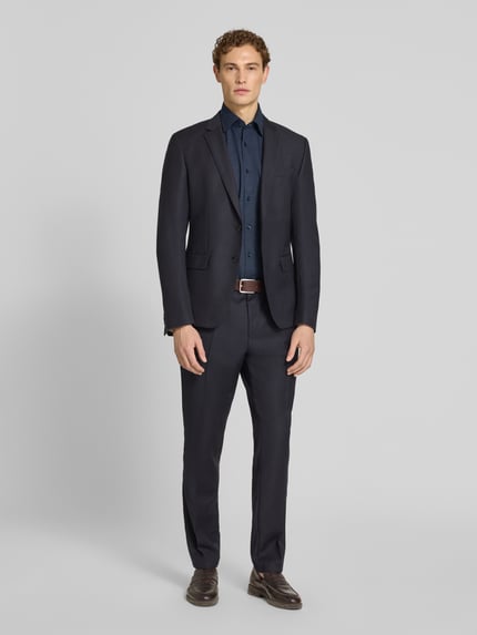 Männermodel trägt Regular Fit Businesshemd aus Baumwoll-Mix Modell 'KENT SH C1' von BOSS, dunkel, Allover-Muster, Ganzkörperansicht von vorne.