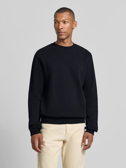 Męski model nosi czarną bluzę Regular Fit Sweatshirt aus reiner Baumwolle model 'BAARO' von Armedangels, gładka faktura, Ganzkörperansicht von przodu, Herren Sweatshirt von Armedangels