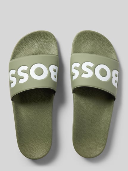 Produktfoto, Badeschuhe mit Logo Print von BOSS in Two-Tone-Optik, abgerundete Schuhspitze, flache Absatzform, Europaproduktion, grün.