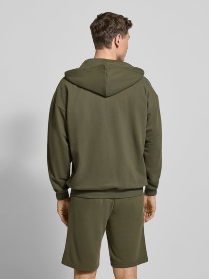 Männermodel trägt Relaxed Fit Sweatjacke aus Baumwoll-Mix von Tommy Hilfiger, Optik: Unifarben, Sweat, Ganzkörperansicht Rückansicht.