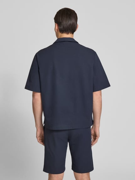 Männermodel trägt dunkelblaues Relaxed Fit Freizeithemd mit Seersucker-Verarbeitung Modell 'LAPISY_M' von BOSS Orange, Ganzkörperansicht Rückansicht.