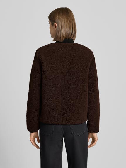 Frauenmodel trägt Fleecejacke mit Zweiwege-Reißverschluss Modell 'Janet' von Carhartt Work In Progress, braunes Teddyfell, Regular Fit, Produktdetails aus dem Kontext, Ganzkörperansicht Rückansicht