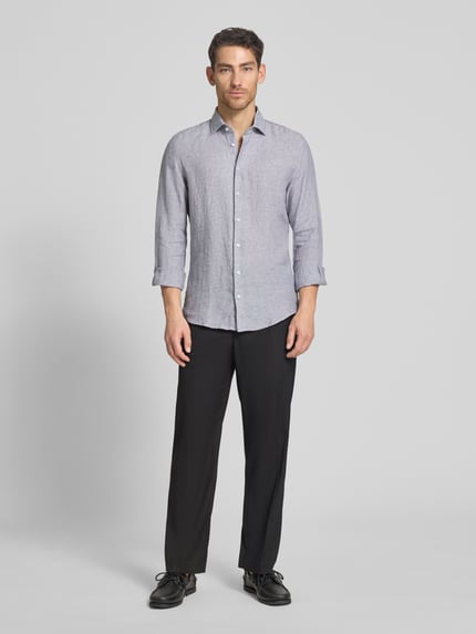 Männermodel trägt Slim Fit Business-Hemd aus Leinen mit Kentkragen von SEIDENSTICKER, graue Farbe, Ganzkörperansicht von vorne, reine Leinen, Slim-Fit, Knopfleiste, Rückenlänge 69 cm, Schulterbreite 43 cm, Ärmellänge 64 cm.