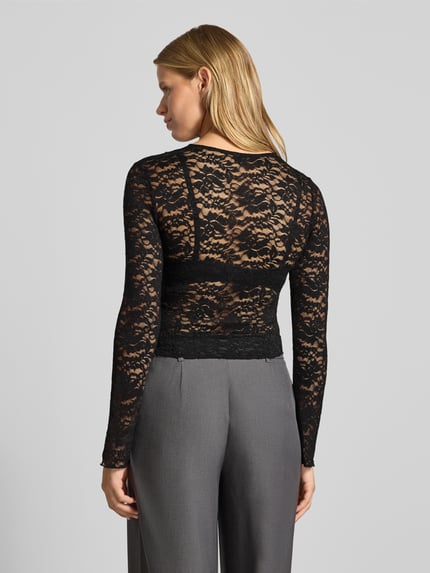 Vrouwenmodel draagt Slim Fit Langarmshirt in mesh-look model 'NIKKA' van ONLY, Dames Langarmshirt, zwarte kanten stof, achterkant volledige lichaamsweergave.