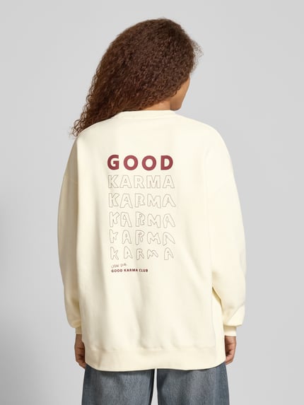 Frauenmodel trägt Sweatshirt mit Rundhalsausschnitt Modell 'Good Karma' von OH APRIL, Oversized, Print auf Rückseite, Baumwoll-Mix, Ganzkörperansicht Rückansicht