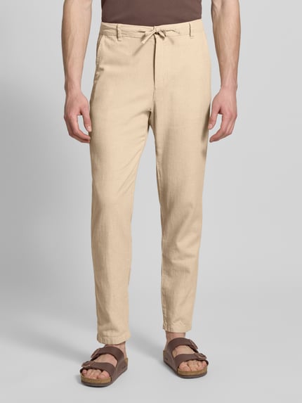 Mężczyznamodel nosi Regular Fit Hose aus Baumwoll-Leinen-Mix Modell 'BRODY' od SELECTED HOMME, beżowy, melanż, tkanina o gładkiej strukturze, z paskiem i kieszeniami, widok przód, ujęcie całej sylwetki z przodu.
